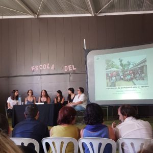 Personal educatiu i famílies de la Granota presenten les seves experiències a Connexions 0-6. A la pantalla, una imatge del jardí de l'escola