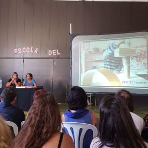 Vanessa i Maria presentant l'experiència d'El Cabusset a Connexions 06. A la pantalla un infant de Cabusset fent una construcció amb peces de fusta