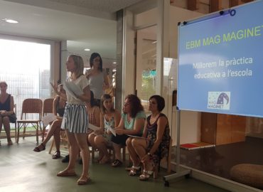 Equip educatiu de Mag Maginet exposant el seu projecte amb presentació sobre pissarra blanca