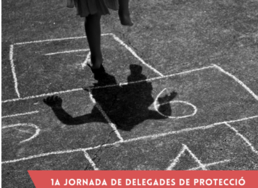 Imatge en blanc i negre. Infant jugant a la xarranca. Infant saltant, es veu de cintura cap avall i la seva ombra sobre el dibuix de la xarranca amb les caselles del 4 al 7